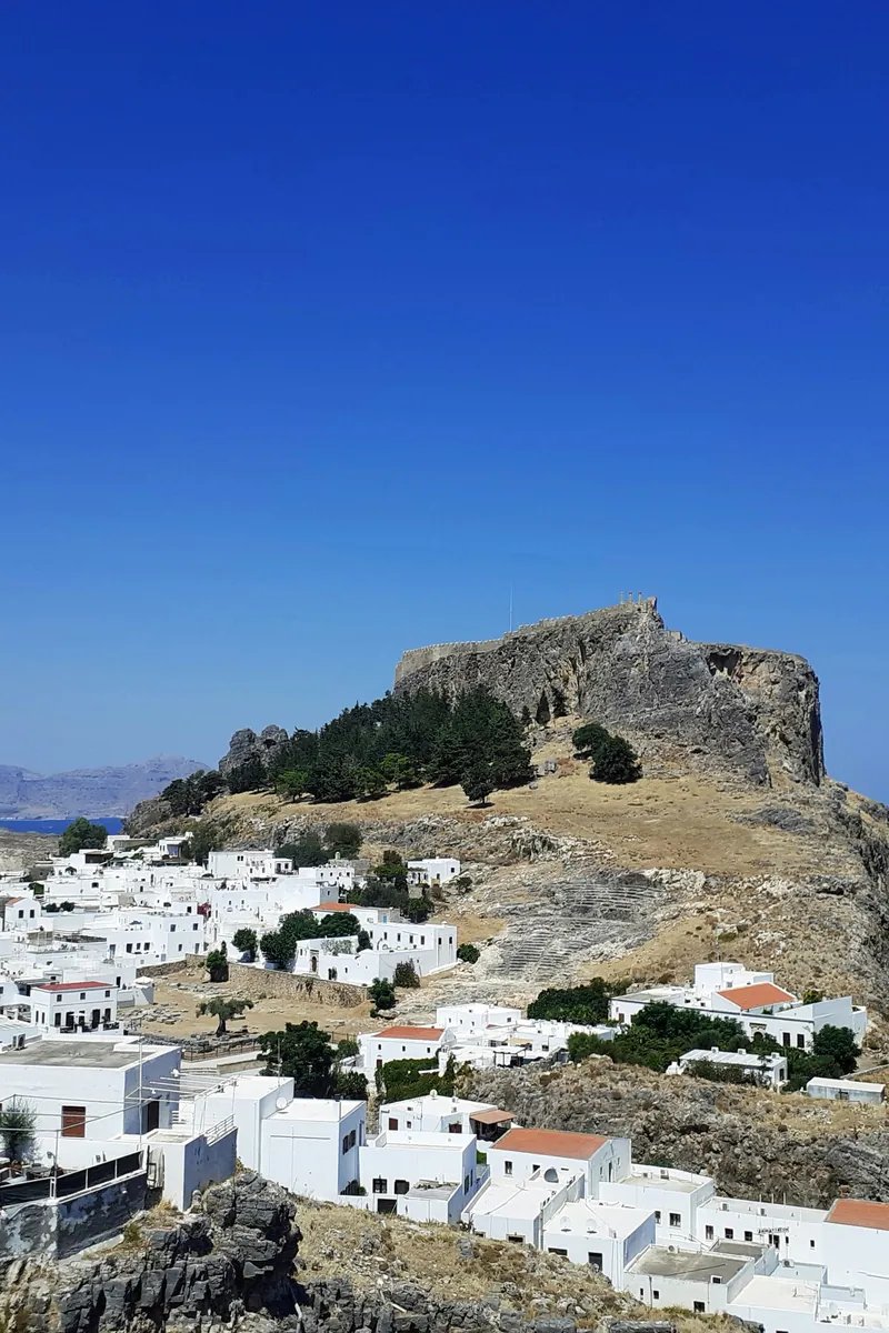 The columns of the Temple of Athena Lindia on the Acropolis of Lindos, high above the whitewashed village and the blue Aegean on Rhodes